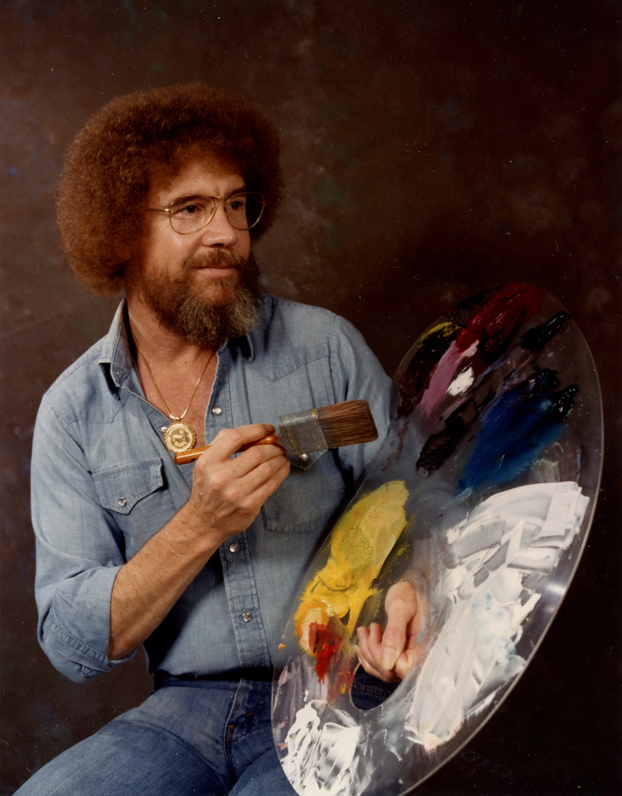 Bob Ross holding a brush and pallet